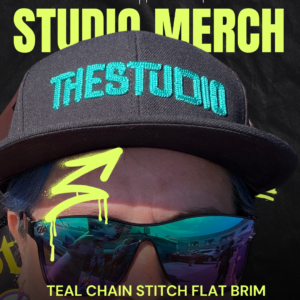 Black hat with teal writing says The Studio